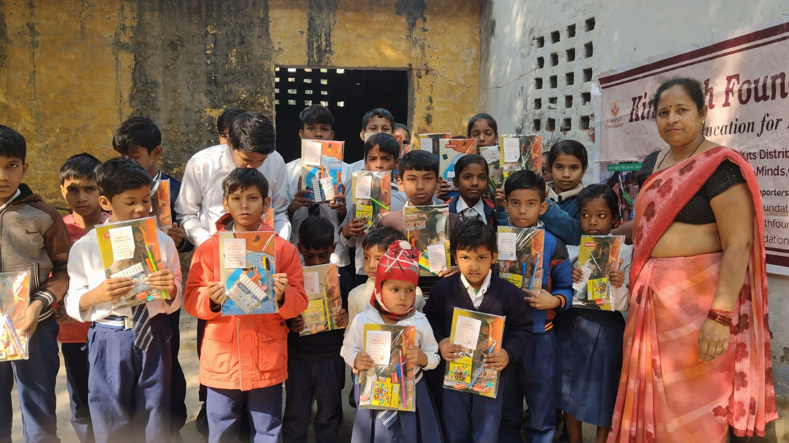School children holding education kits distributed by Kindpath Foundation