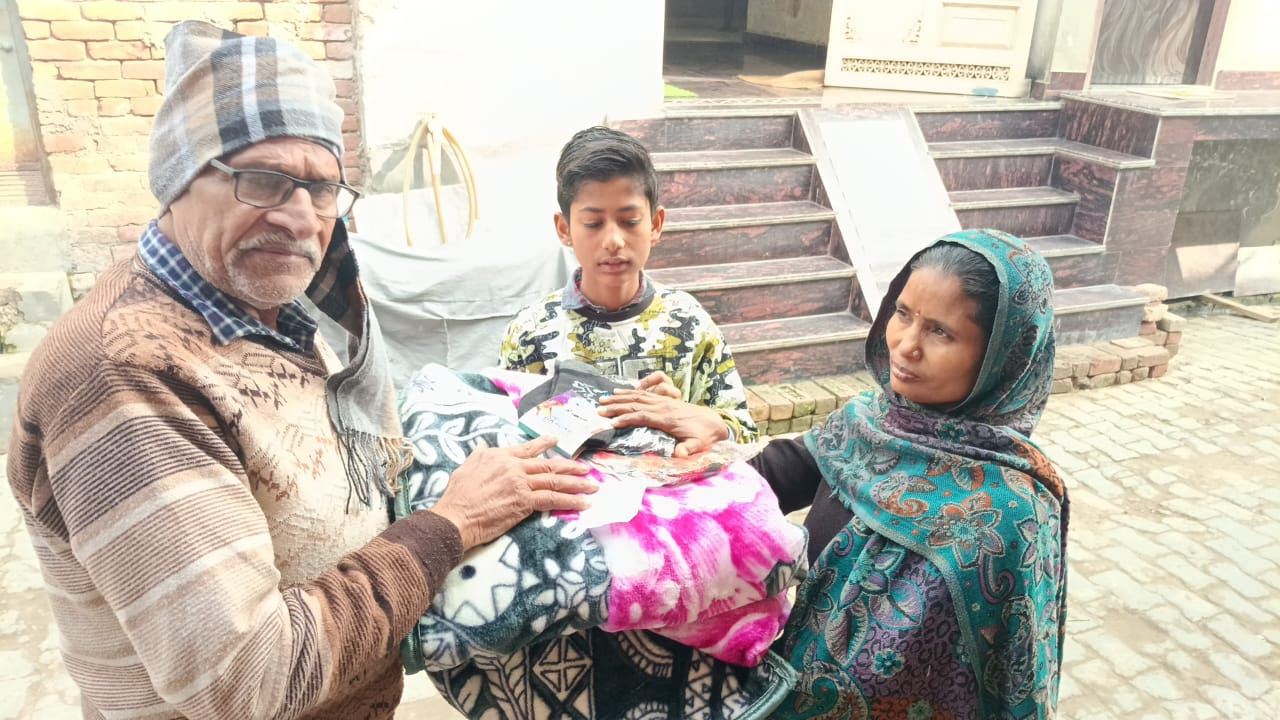 A family receiving blankets and essential supplies from Kindpath Foundation